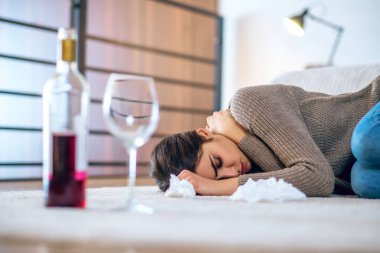 Depresyonda olan ve alkol alan genç bir kadın.