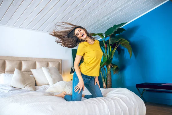 Långhårig vacker ung kvinna ser glad och viftar med håret i luften — Stockfoto