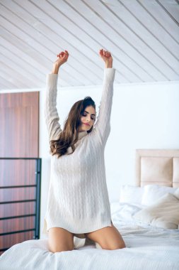 Koyu saçlı genç kadın esniyor ve uykulu hissediyor.