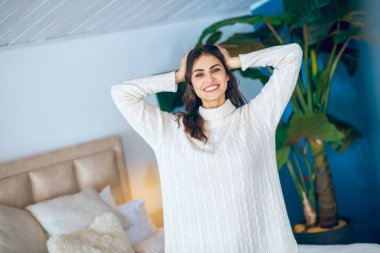 Koyu saçlı genç kadın kendini rahat ve uykulu hissediyor.