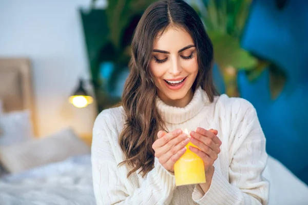 Joven hermosa mujer en ropa blanca sosteniendo una vela encendida — Foto de Stock