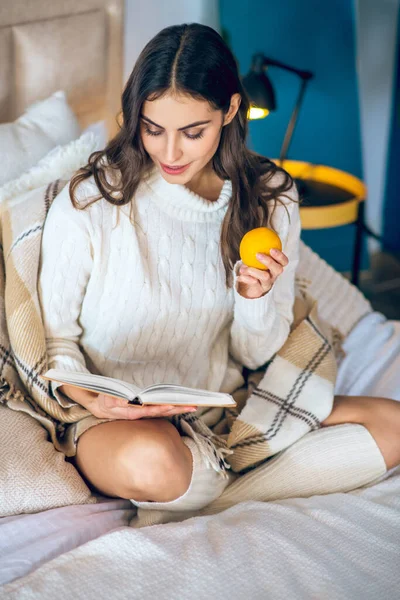 Junge schöne Frau liest ein Buch in ihrem Schlafzimmer — Stockfoto