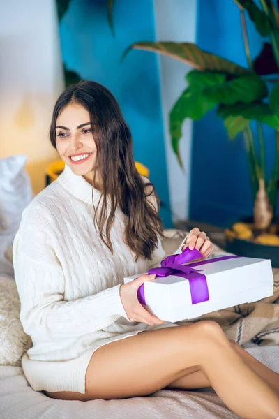 Dark-haired woman holding a present in her hands — Stock Photo, Image