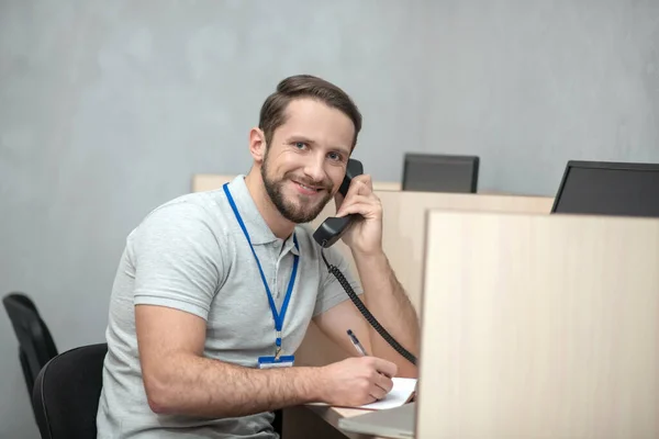 Усміхнений чоловік з телефонним приймачем біля вуха — стокове фото
