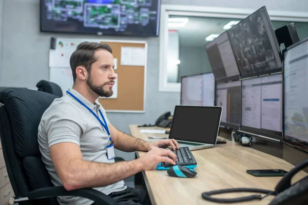 Uomo guardando gli schermi del computer seduto alla tastiera — Foto Stock