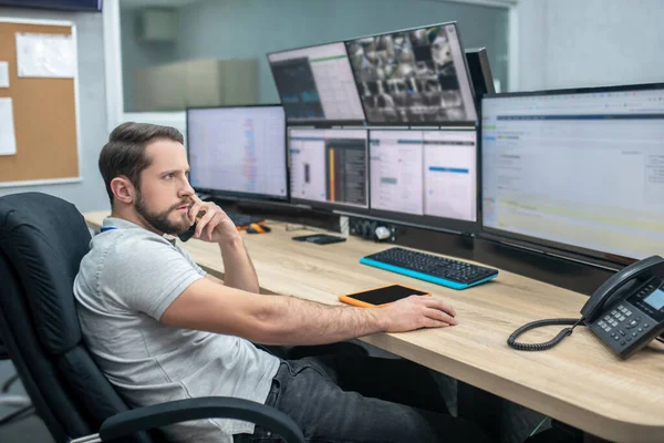 Hombre observador implicado en silla delante de monitores — Foto de Stock