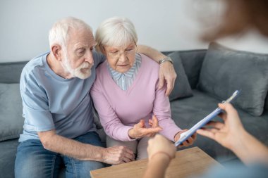 Yaşlı çiftin sağlık sigortası acentesiyle randevusu var.