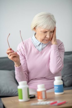 Son sınıf öğrencisi kanepede oturuyor ve kendini kötü hissediyor.