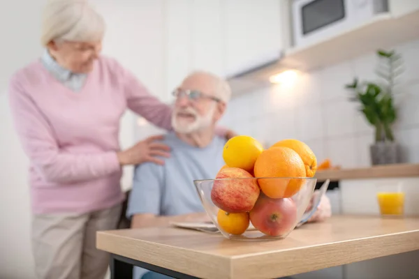 Donna anziana dai capelli grigi che sorride e tocca la spalla dei mariti — Foto Stock