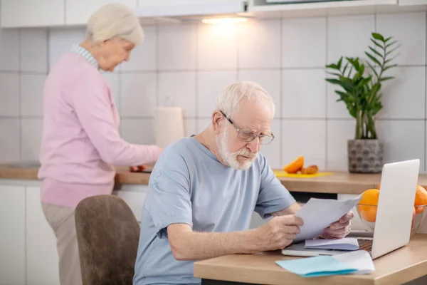 Baard senior man leest iets en kijkt serieus — Stockfoto