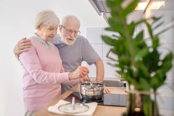 Starší pár vaří společně v kuchyni a cítí se dobře — Stock fotografie