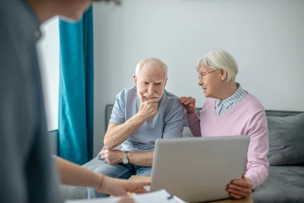 Starsza para umawiająca się z pracownikiem ubezpieczenia zdrowotnego i omawiająca szczegóły umowy — Zdjęcie stockowe
