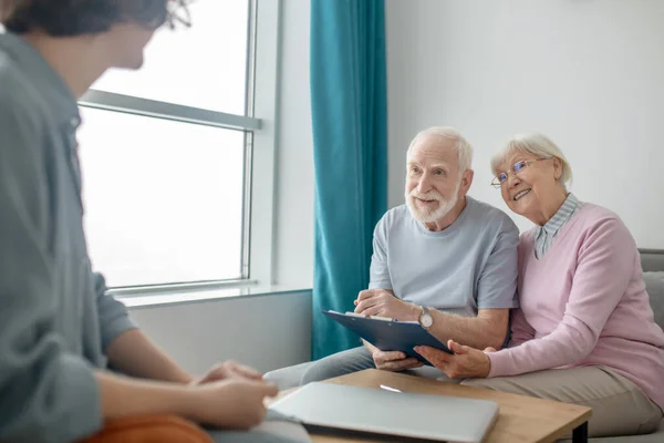 Senior couple talking to insurance company agent and looking involved — Stock Photo, Image