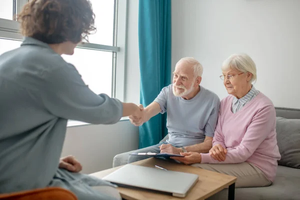 Oudere paar vergadering verzekeringsmaatschappij agent en kijken betrokken — Stockfoto