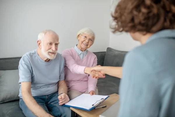 Oudere paar vergadering verzekeringsmaatschappij agent en kijken betrokken — Stockfoto