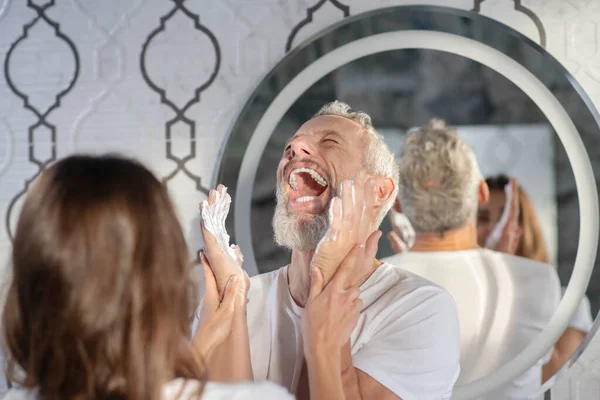 Супруги веселятся, играя с пеной для бритья — стоковое фото