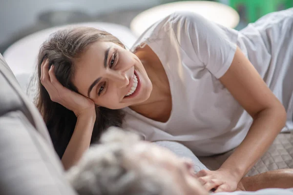 Vrouw die met een man praat terwijl ze in bed blijft — Stockfoto