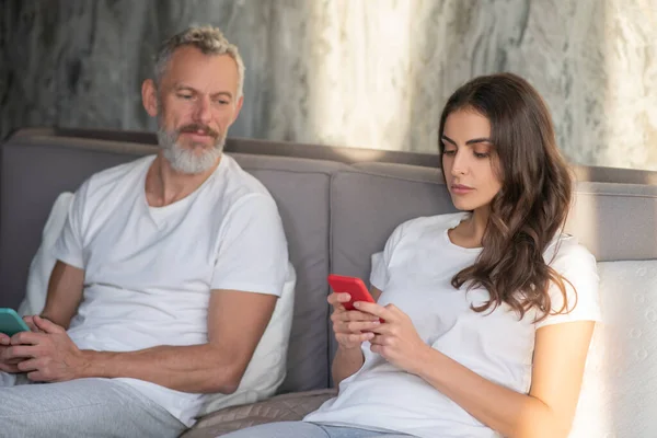 Man looking on her wife using a smartphone — Stock Photo, Image