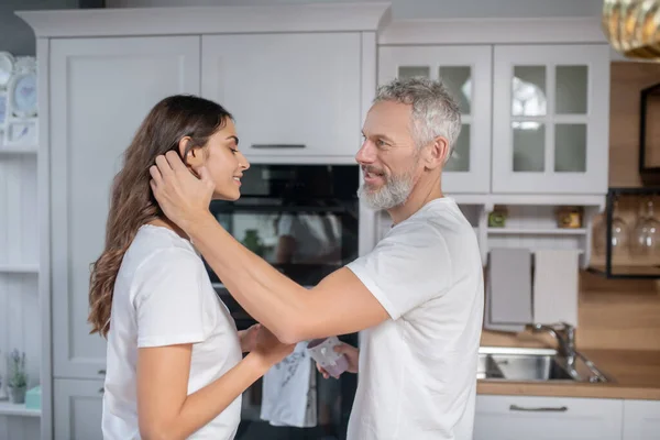 Hombre de pelo gris abrazando a su hermosa joven esposa — Foto de Stock