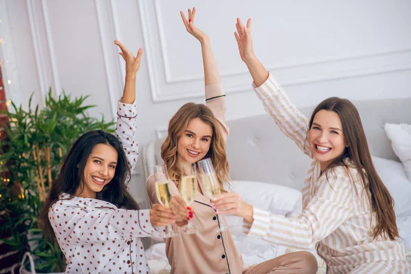 Chicas guapas dando una fiesta de pijama y bebiendo champán — Foto de Stock
