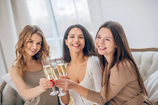 Tres chicas jóvenes teniendo una despedida de soltera y bebiendo champán — Foto de Stock
