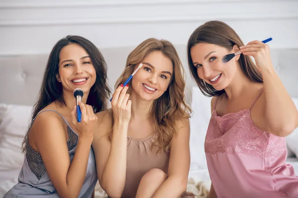 Chicas guapas haciendo maquillaje y viéndose felices — Foto de Stock