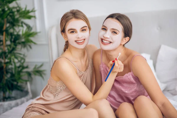 Две девушки проходят косметические процедуры и чувствуют себя счастливыми — стоковое фото