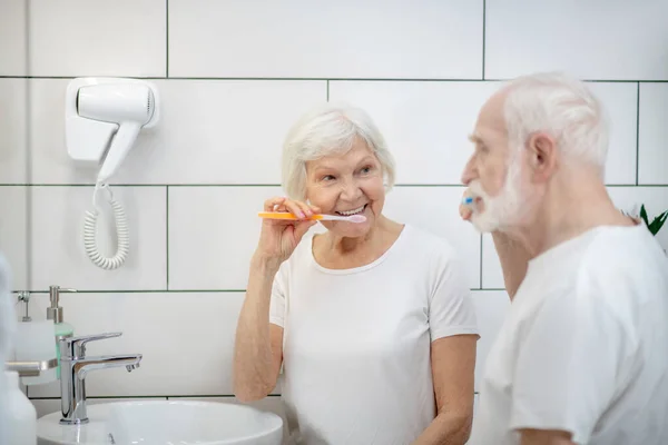 Літня пара чистить зуби разом і відчуває себе добре — стокове фото