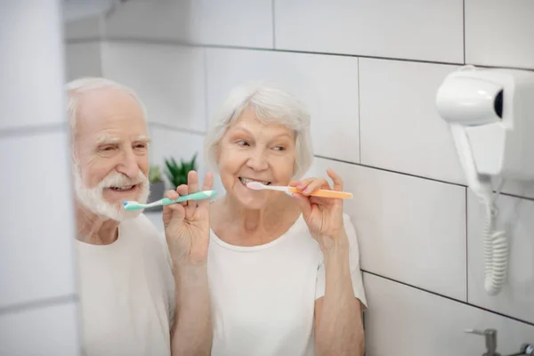Пожилая пара чистит зубы и чувствует себя хорошо — стоковое фото