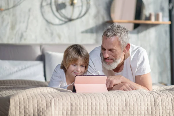 Feliz papá sonriente con bebé con tableta —  Fotos de Stock