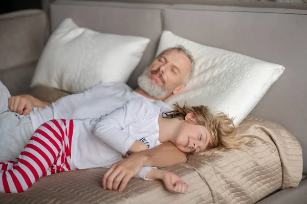 Hombre y niño acostados con los ojos cerrados — Foto de Stock