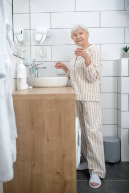 Banyoda sabah ameliyatı yapan yaşlı bir kadın.