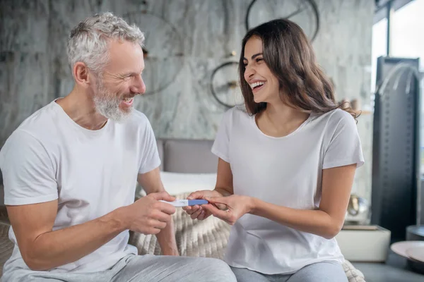 Shining excited husband and wife with pregnancy test — Stock Photo, Image