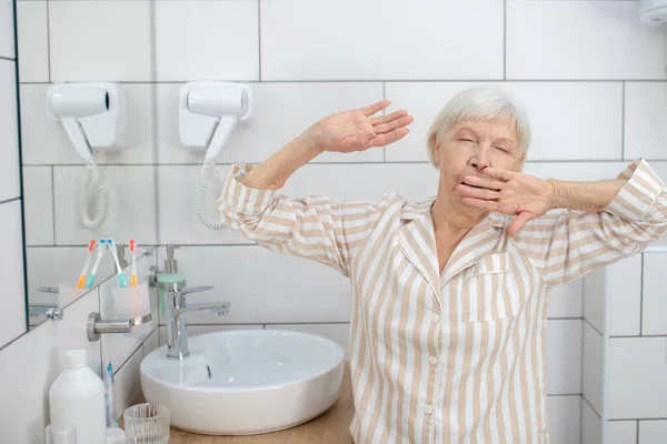 Mujer de pelo gris sintiendo sueño y bostezo — Foto de Stock