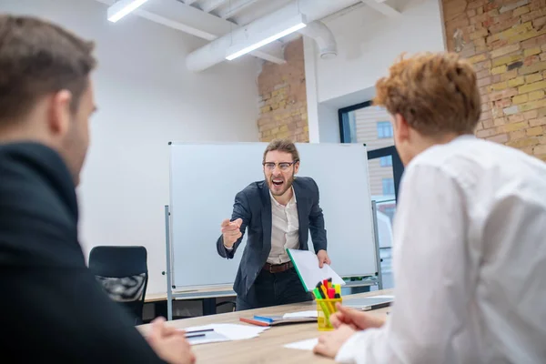 Mérges, szemüveges férfi kiabál az alkalmazottakkal. — Stock Fotó