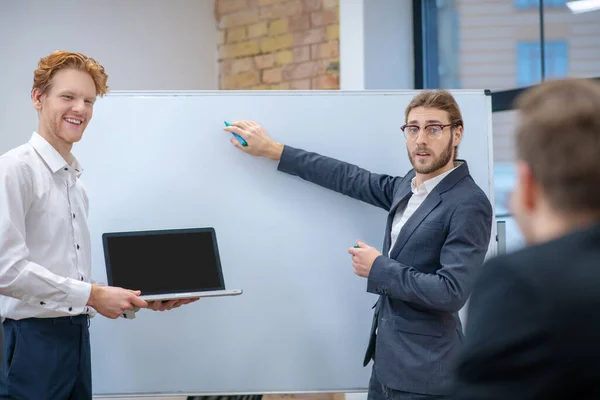 Två män med laptop står nära monter — Stockfoto