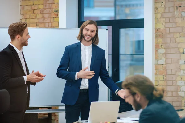 Nöjd man i kostym och kollega klappa händer — Stockfoto