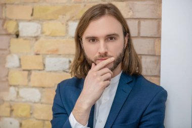 Genç düşünceli adam el ele tutuşuyor.