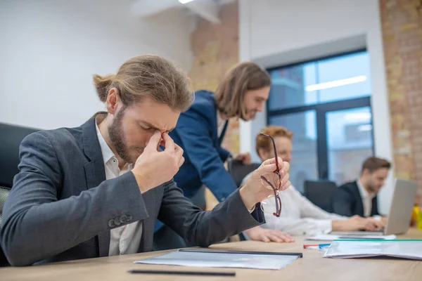 Trött man med slutna ögon sitter på kontoret — Stockfoto