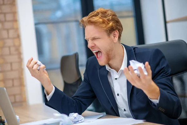 Wściekły krzyczący mężczyzna siedzący w miejscu pracy — Zdjęcie stockowe