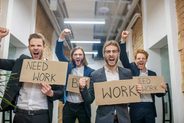 Ofiste işsizlik afişleri taşıyan adamları toplamak