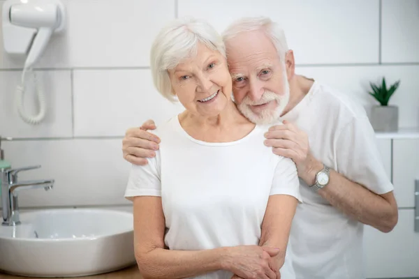 Starsza para w łazience wygląda szczęśliwie i uśmiechnięta — Zdjęcie stockowe