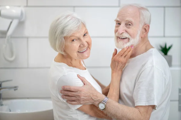 Elderly couple in the bathroom looking happy and smiling — Stock Photo, Image