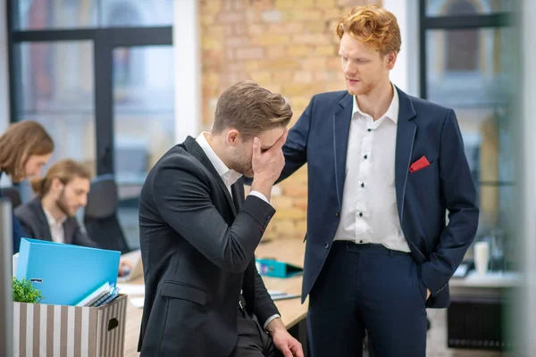 Redhaired man stödja olycklig kollega i ämbetet — Stockfoto