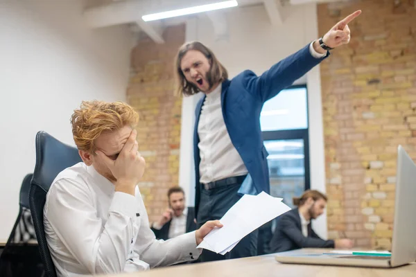 Unglücklicher Mann mit Papieren und wütender Kollege — Stockfoto