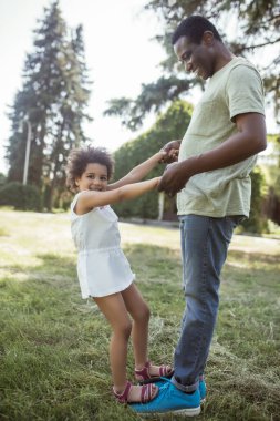 Şirin kıvırcık çocuk babasıyla oynuyor ve mutlu.