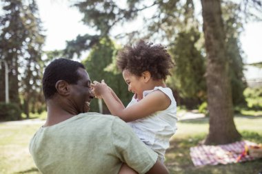 Tatlı kıvırcık çocuk babasıyla oynuyor ve mutlu.