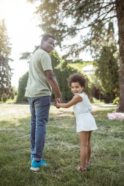 Tatlı kıvırcık çocuk babasıyla oynuyor ve mutlu.