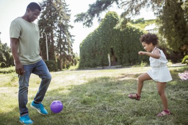 Babam ve parkta top oynayan tatlı bir kız.