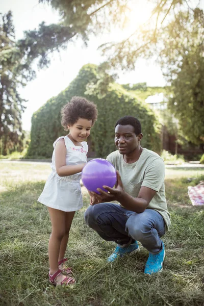Africký Američan drží míč a mluví se svým dítětem — Stock fotografie